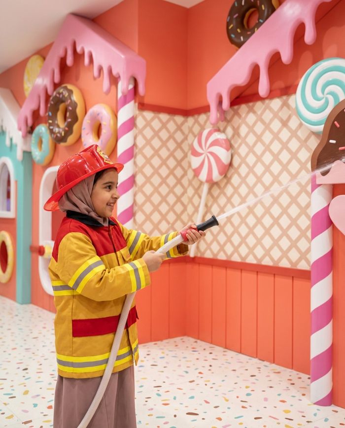 Child firefighter with a hose